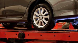 Car tire on lift before alignment.